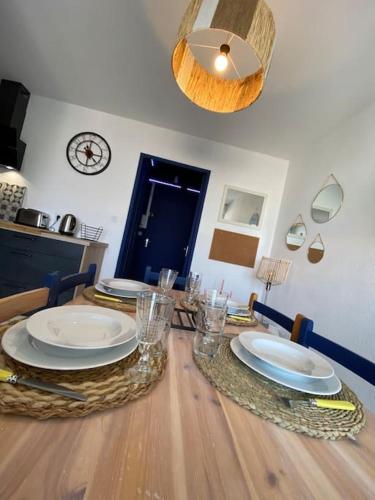 - une table à manger avec des assiettes au-dessus dans l'établissement Logement entier 6 pers à 500m de la plage, à Sète