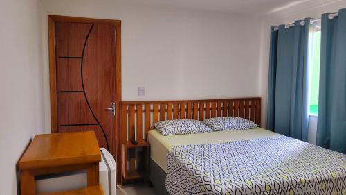 a bedroom with a bed and a wooden door at Praieira Hostel&Pousada in Itacaré