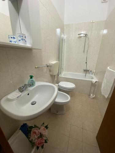 Baño blanco con lavabo y aseo en Domus Vacanza, en Milán