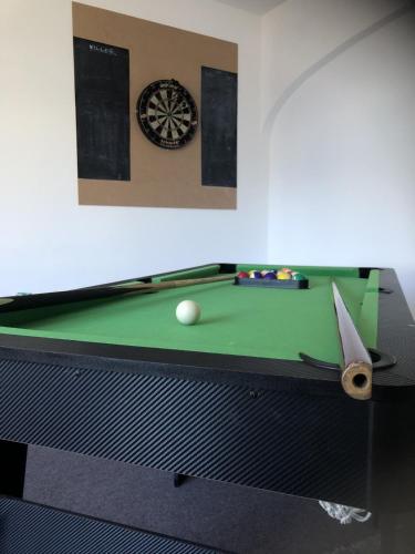 a pool table with a ball and a dartboard at Myrtle villa 10 bedrooms sleeps 28, 2 min to beach in Weymouth