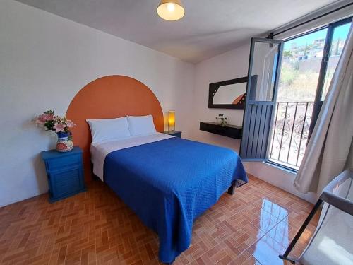 a bedroom with a bed and a large window at Beautiful rustic-style house close to downtown in Guanajuato