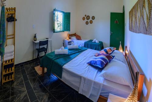 Un dormitorio con dos camas con almohadas azules. en Casarão das artes hospedaria, en Cumuruxatiba