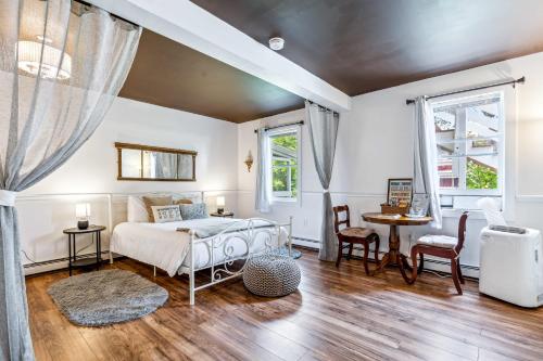 1 dormitorio con 1 cama, mesa y sillas en Woodstock Suite at The Bridgewater Inn, en Bridgewater