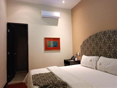 a hotel room with a bed and a window at Hotel Merida in Mérida