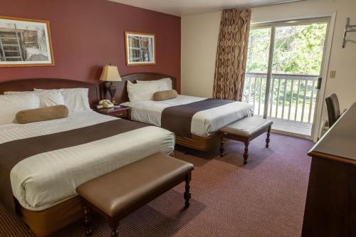 a hotel room with two beds and a balcony at AbbyCreek Inn in Winthrop