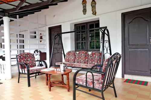 奇克马格尔Jungle Greens Homestay - Water Activities, Near to Jungle Safari的一间设有两把椅子、一张桌子和一张桌子的房间