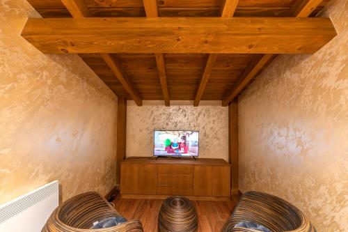 a living room with a tv and two chairs at Pirin Golf Hotel&Spa Apartment 17 - private luxury apartment in Razlog