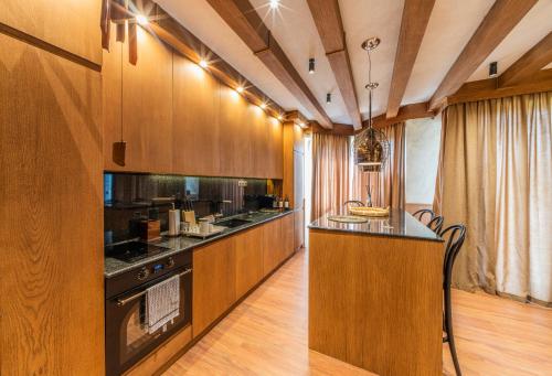 a kitchen with wooden cabinets and a counter top at Pirin Golf Hotel&Spa Apartment 17 - private luxury apartment in Razlog