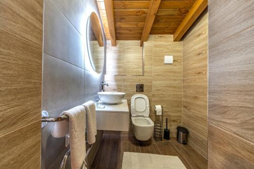 a bathroom with a white toilet and a sink at Pirin Golf&Spa Apartment 17 in Razlog