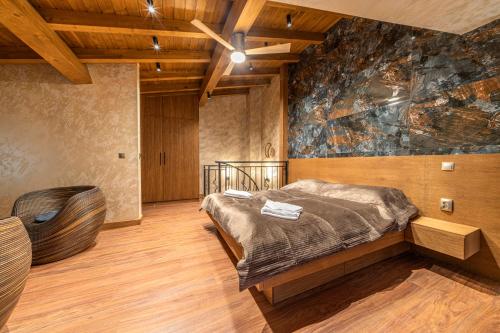 a bedroom with a bed and a large painting on the wall at Pirin Golf Hotel&Spa Apartment 17 - private luxury apartment in Razlog