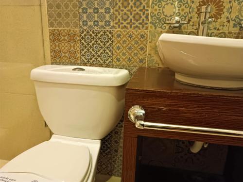 a bathroom with a white toilet and a sink at Hotel Merida in Mérida