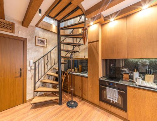 a spiral staircase in a kitchen with wooden cabinets at Pirin Golf Hotel&Spa Apartment 17 - private luxury apartment in Razlog