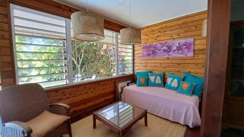 a bedroom with a bed and a couch and a table at TAHITI - Villa Fara in Papara