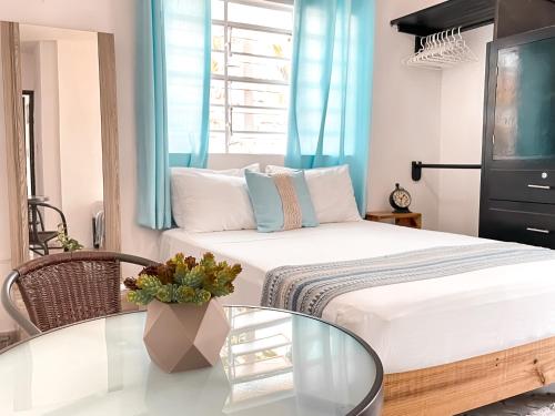 a bedroom with a bed and a glass table at Casa Momo Bacalar in Bacalar