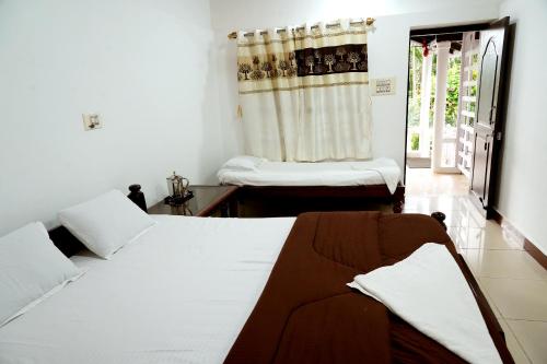 um quarto com 2 camas num quarto com uma janela em Jungle Greens Homestay - Safari Ride & Near to View Points em Chikmagalūr