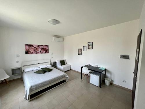 a bedroom with a bed and a desk in it at Cristian Rooms in Avola
