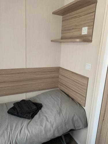 a small bed in a small room with a shelf at Hot tub breakaways with castle view in Lincolnshire
