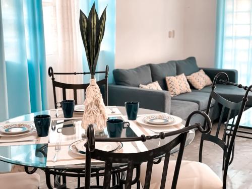 a living room with a table and chairs and a couch at Casa Momo Bacalar in Bacalar