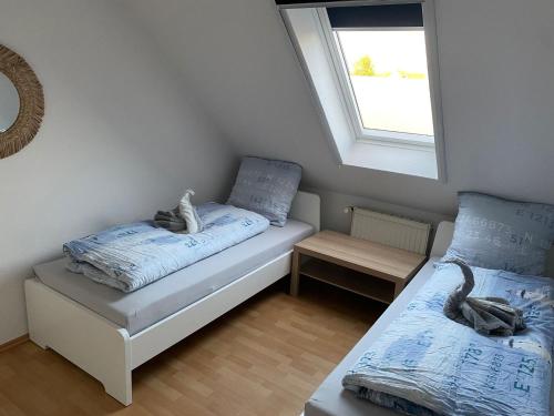 um pequeno quarto com 2 camas e uma janela em Zaunkönigin em Norden