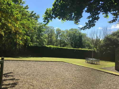 a park with a bench sitting on the grass at Chatton Park House Adult Only in Chatton