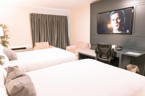 a hotel room with two beds and a flat screen tv at Hotel Civilia Lakeside by Civilia Golf Retreat in Clearwater