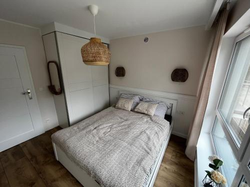 a small bedroom with a bed and a window at Apartament Szumilas Rowy in Rowy