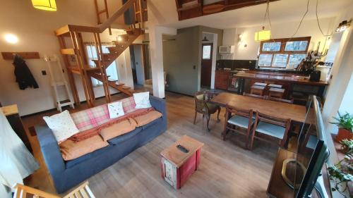 een woonkamer met een bank en een eetkamer bij CASA DE LA LAGUNA in Ushuaia