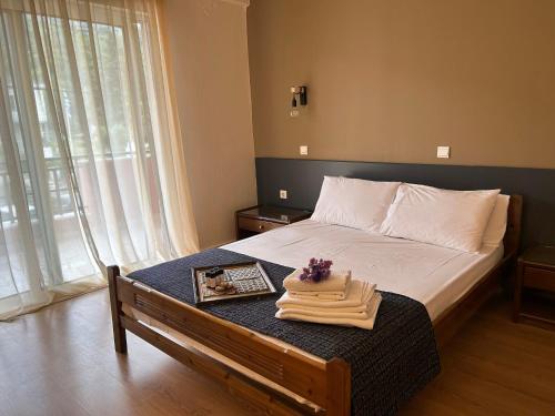 1 dormitorio con 1 cama con mesa y toallas en Βαδόκειος ΓΗ, en Zítsa