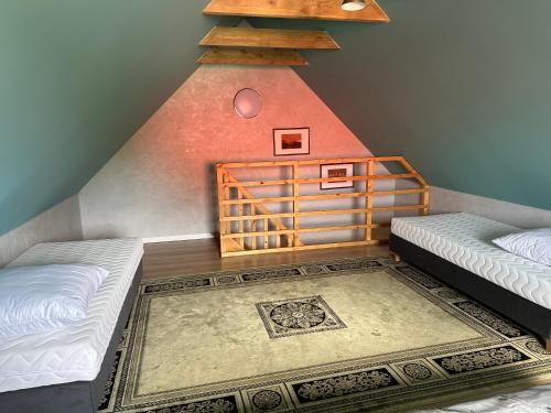 a attic room with two beds and a staircase at U Zgagi in Mikoszewo