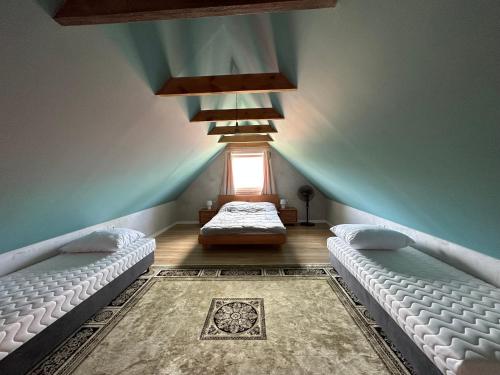 a attic room with two beds and a window at U Zgagi in Mikoszewo