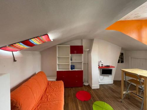 uma sala de estar com um sofá laranja e uma mesa em Penthouse by Roland-Garros em Boulogne-Billancourt