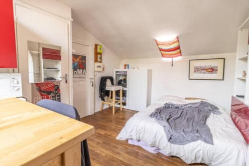 um quarto com uma cama e uma mesa em Penthouse by Roland-Garros em Boulogne-Billancourt