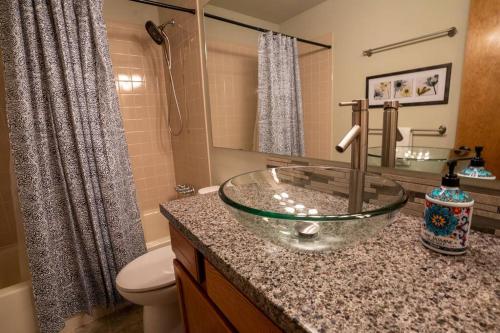 baño con lavabo de cristal en una encimera en Hillcrest Chalet - Spa - Mountain Views - Fire Pit - Slide -9min to USAFA en Colorado Springs