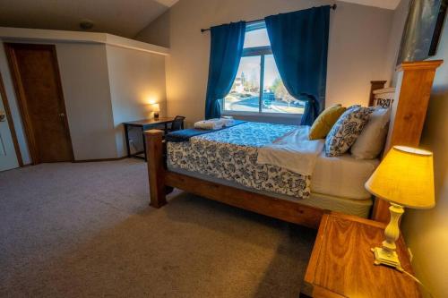 a bedroom with a large bed with a window at Hillcrest Chalet - Spa - Mountain Views - Fire Pit - Slide -9min to USAFA in Colorado Springs