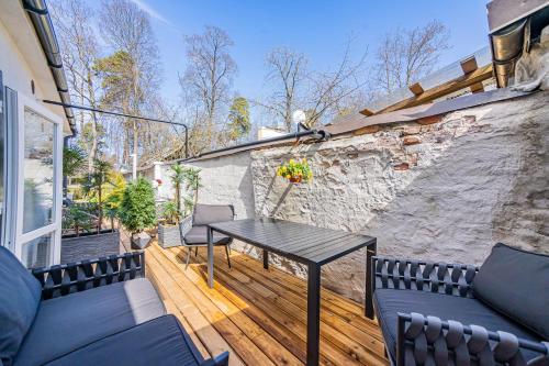 a patio with a table and chairs on a wooden deck at Tamara Suites & Apartments in Jūrmala