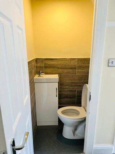 a bathroom with a white toilet and a sink at 4 Bed Family Home in Woodford Green