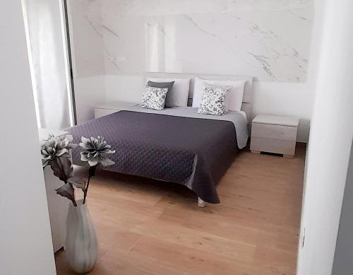 a bedroom with a bed and a vase with flowers at Villa Rosa B&B in Sellia Marina