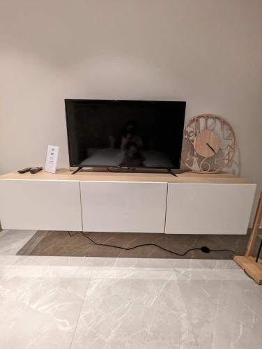 a white entertainment center with a flat screen tv on it at Archimède Suites in Brussels