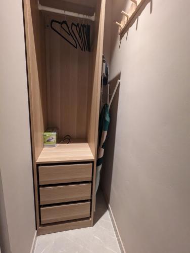a small closet with a wooden cabinet and a staircase at Archimède Suites in Brussels
