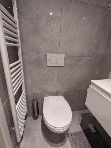 a bathroom with a white toilet and a sink at Archimède Suites in Brussels