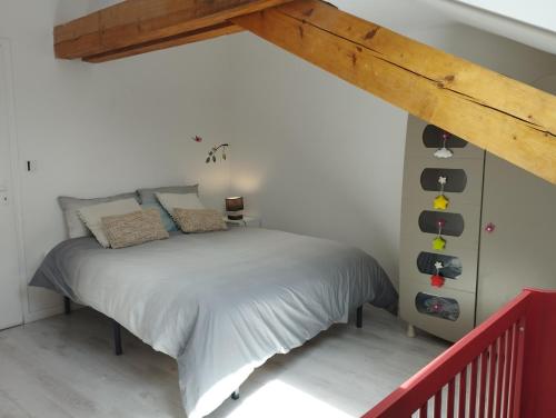 a bedroom with a bed and a wooden beam at Villa Armonia, piscine chauffée, jacuzzi et jardin à 5mn du lac d Annecy in Doussard
