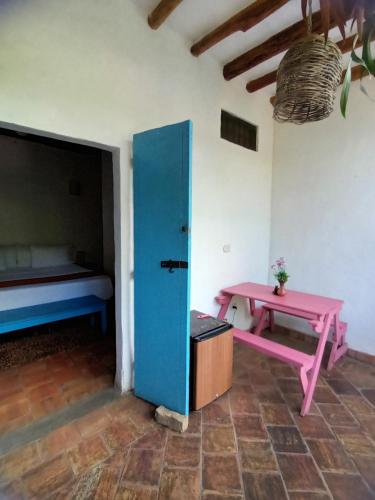 a room with a table and a bench and a bed at Casona CHARA in Barichara