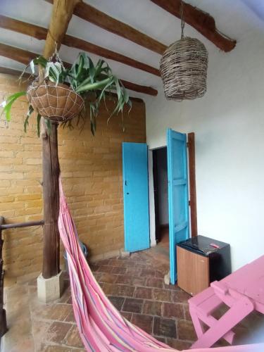 a hammock in a room with blue doors at Casona CHARA in Barichara