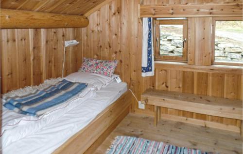 uma cama num chalé de madeira com uma janela em 4 Bedroom Awesome Home In Heidal em Heidal