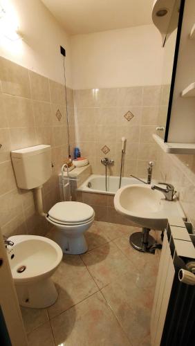 a bathroom with a toilet and a sink and a tub at UN BALCONE IN PINETA in Fezzano