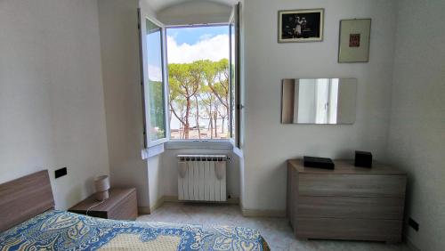 a bedroom with a bed and a large window at UN BALCONE IN PINETA in Fezzano