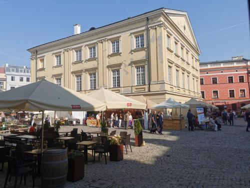 a large building with tables and umbrellas in a courtyard at Town Square Apartment in Lublin