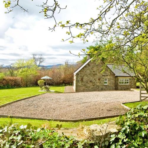 a gravel driveway in front of a stone house at Chatton Park House Adult Only in Chatton