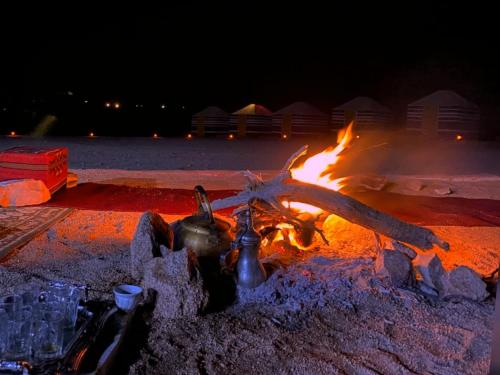 a fire pit with a pot and a star on it at Wadi Rum Orion Camp in Wadi Rum