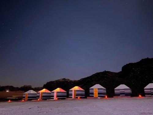 a row of tents in a parking lot at night at Wadi Rum Orion Camp in Wadi Rum